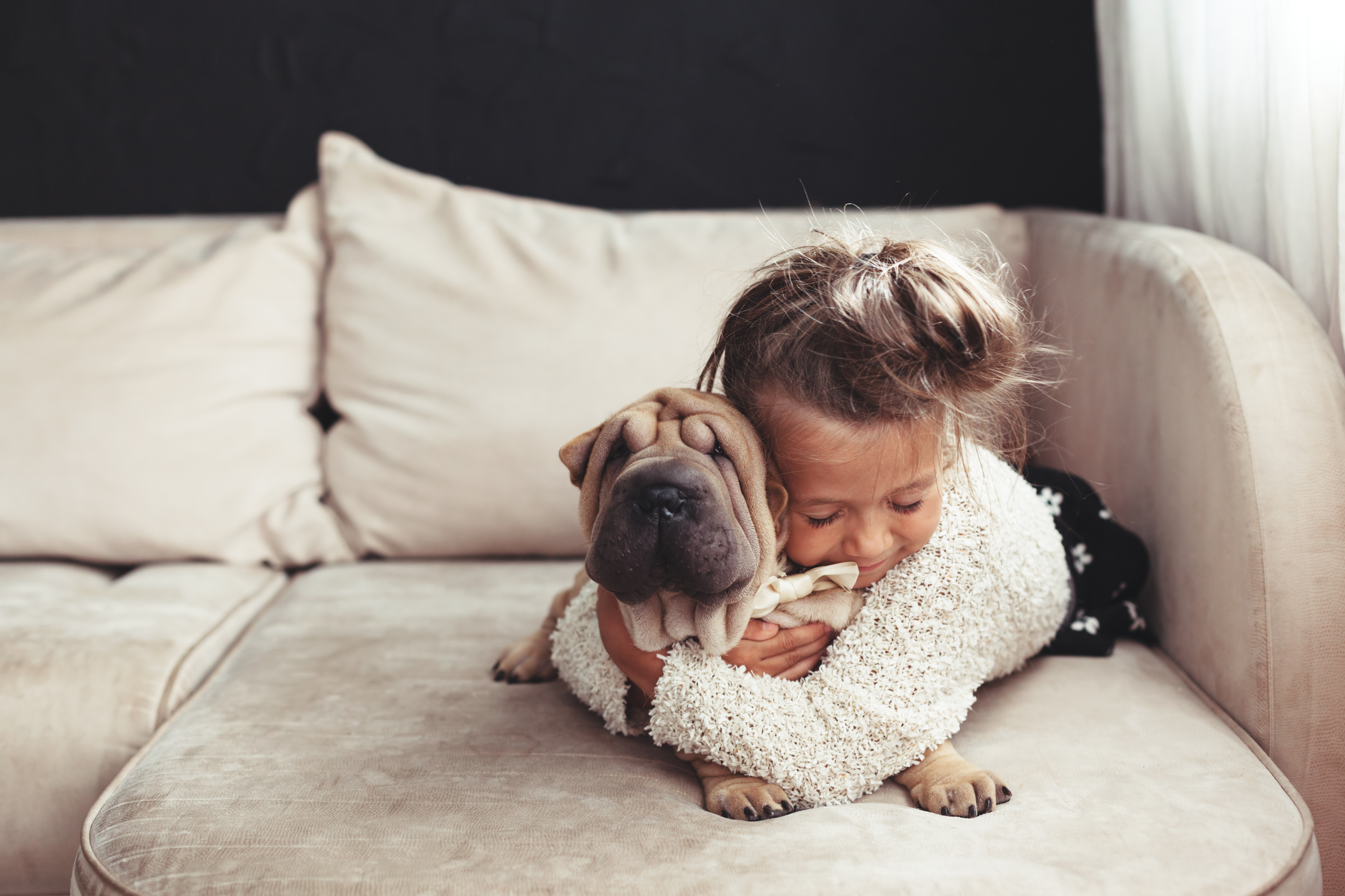 little girl cuddling with dog