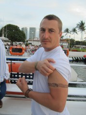 Jason Barrett flexing, showing arm tattoo 