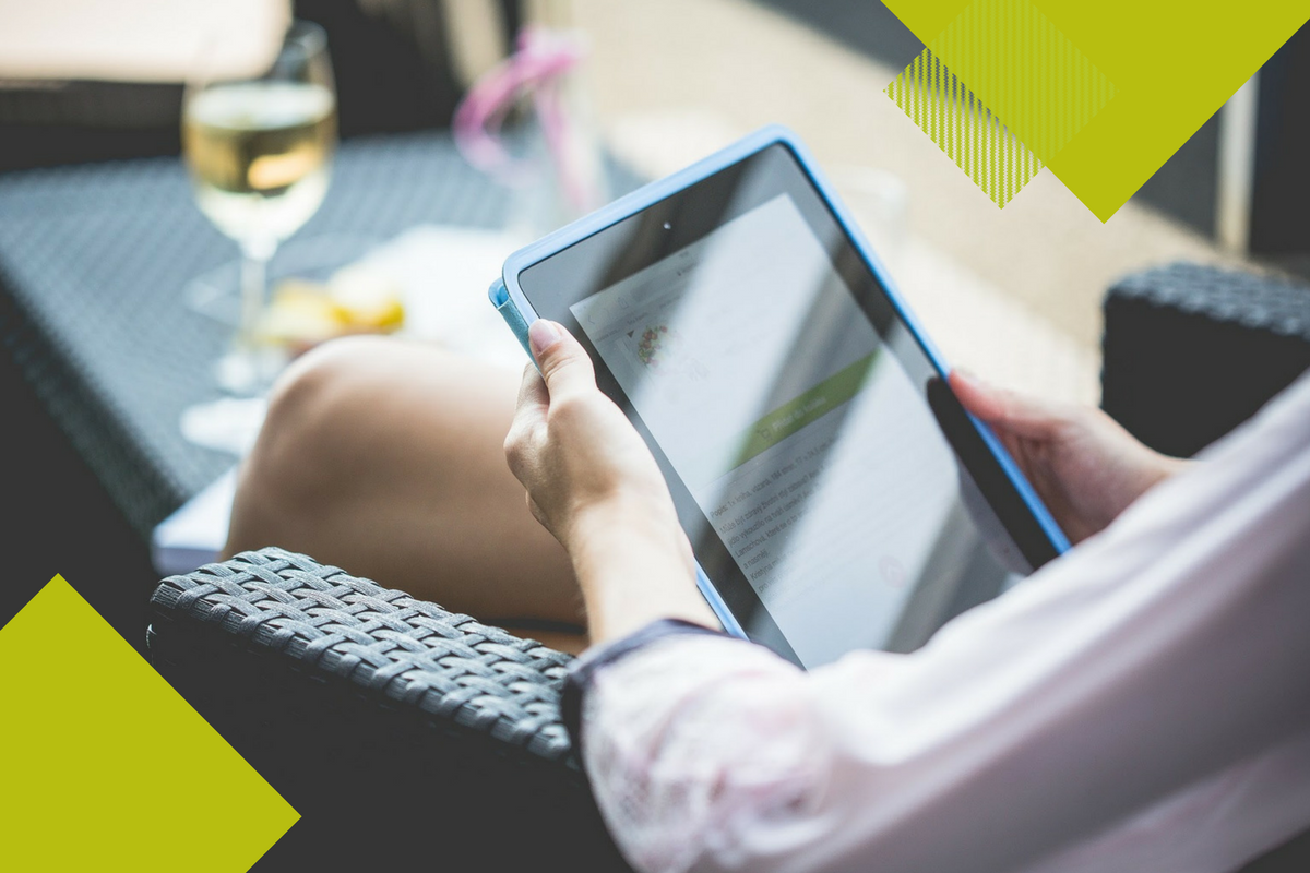 woman sitting at a table with a glass of wine on a tablet with green geometric overlays