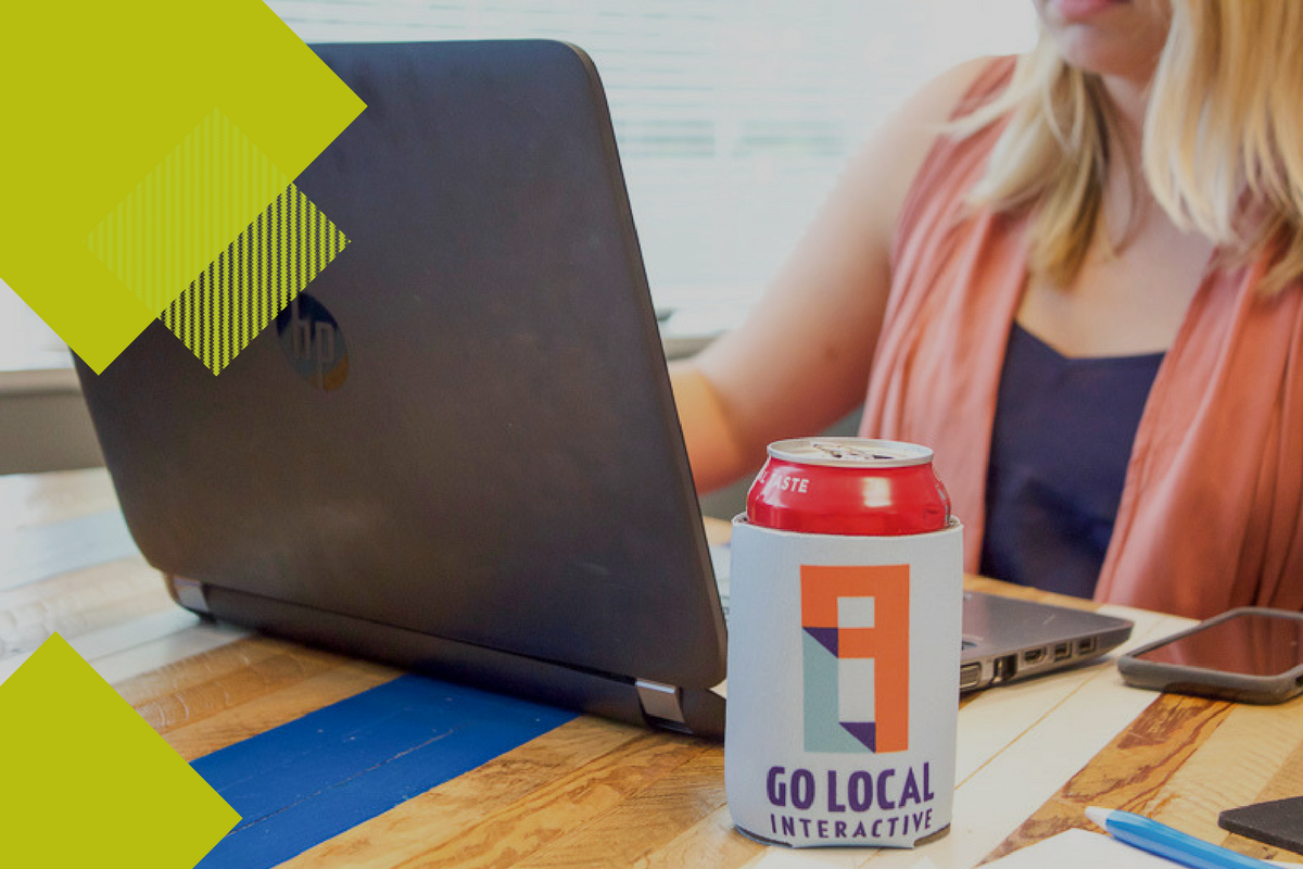 girl looking at computer with soda can and Go Local Interactive koozie 