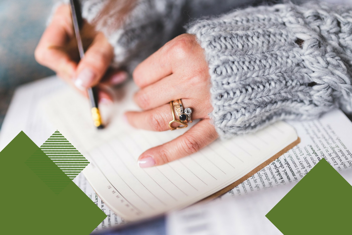 woman's hands writing in notebook