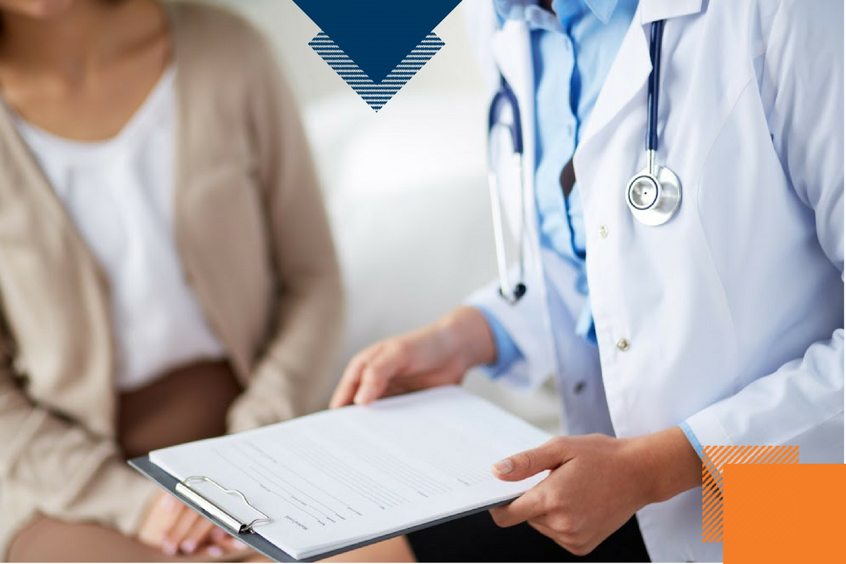 doctor holding piece of paper with patient next to her