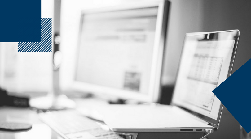 monitor and laptop sitting on a desk in black and white