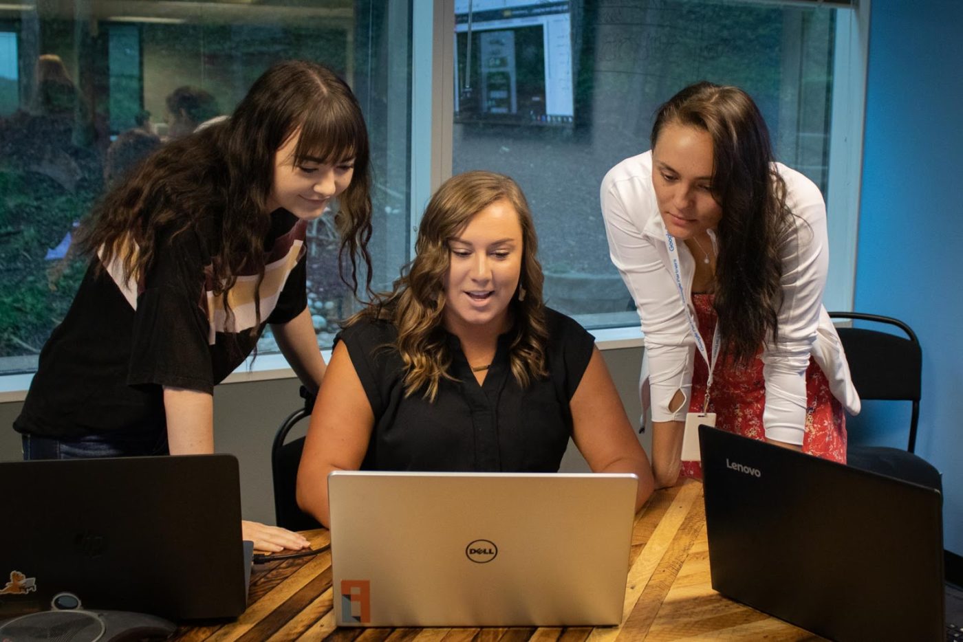 Go Local Interactive interns looking at a laptop screen