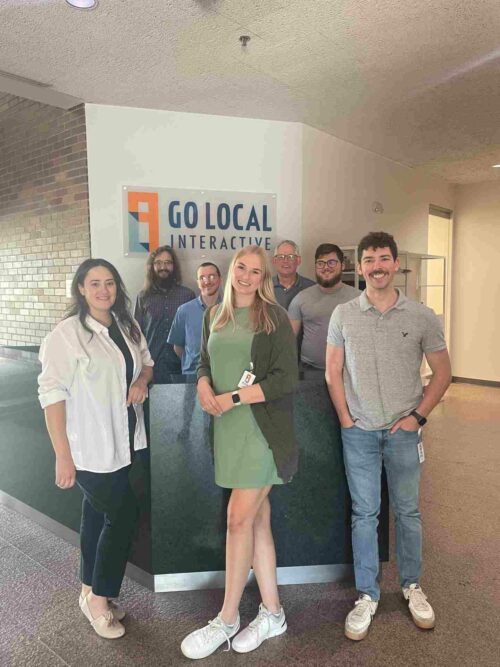 Our June hires standing around the front desk at our headquarters in Overland Park.