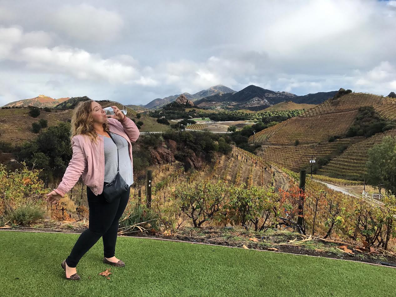 Ashley drinking wine with a beautiful landscape