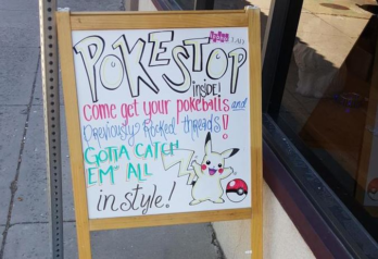 Sign that says "Poke Stop inside! come get your pokeballs and previously rocked threads! Gotta catch em all in style!"